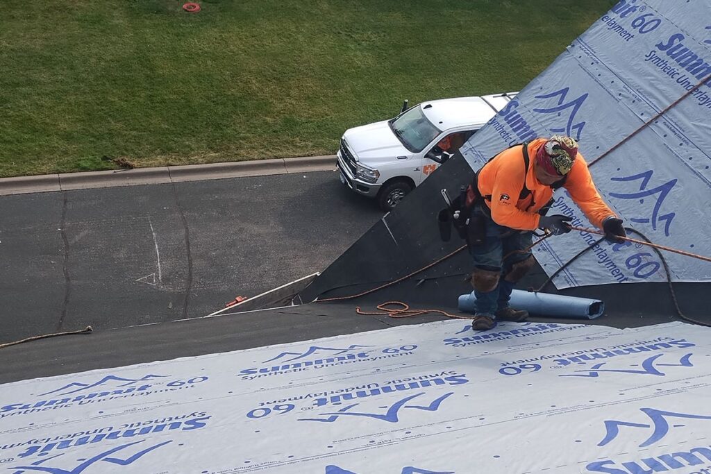 the kingdom builders roofer using rope to climb