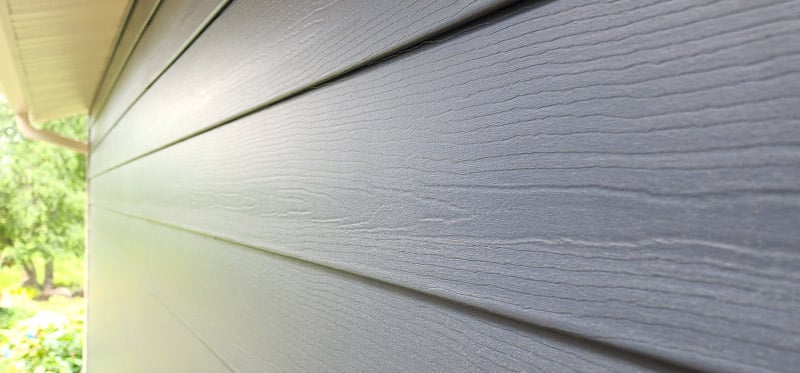 a photo of composite siding in a blue color showing the texture of the siding
