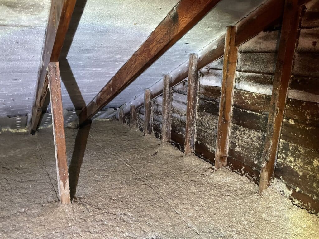 inside an attic showing the build up of ice on the underside of the roof deck from condensation.