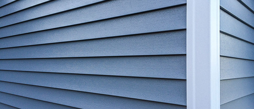 Blue vinyl siding with a white vinyl corner