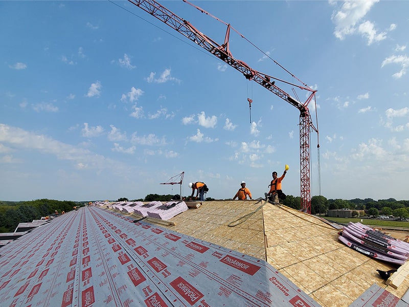 the kingdom builders roofing crew waving at camera