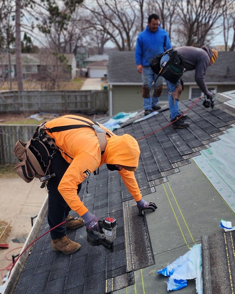 crew installing roofing on single story rambler