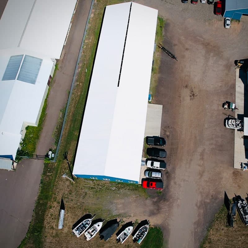 drone shot of long commercial shop with white roof coating