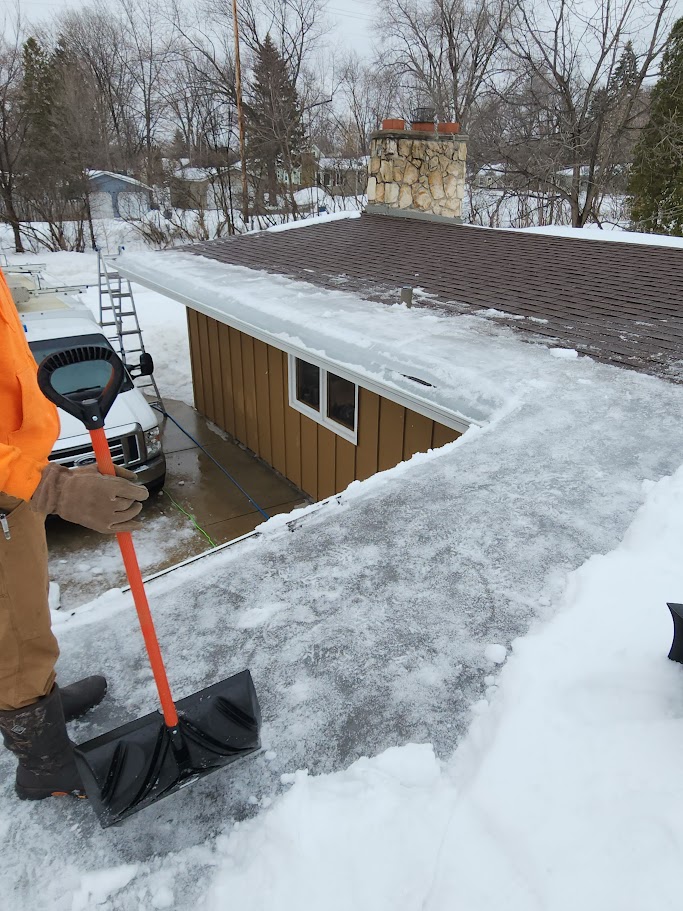 Photo of an ice dam that has had the snow cleared away so you can see all the ice on the roof.